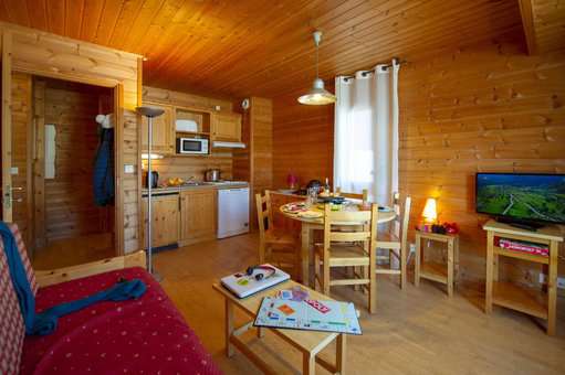 Living room with fully equipped kitchen in the Goélia Les Chalets des Marmottes vacation residence in St Jean d'Arves