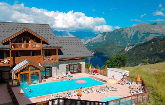 Outdoor heated swimming pool of the holiday residence Goélia Les Alpages du Corbier in summer