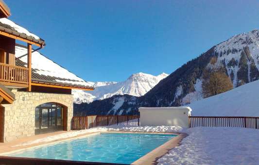 Outdoor heated swimming pool of the holiday residence Goélia Les Alpages du Corbier in winter
