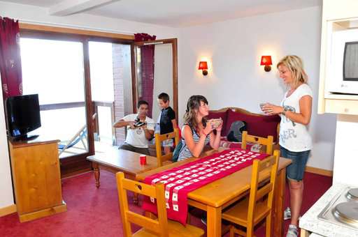Salon avec kitchenette d'un appartement de la résidence de vacances Goélia Les Terrasses du Corbier au Corbier en été