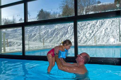 Indoor and outdoor heated swimming pool of the holiday residence Goélia Les Terrasses du Corbier au Corbier in winter