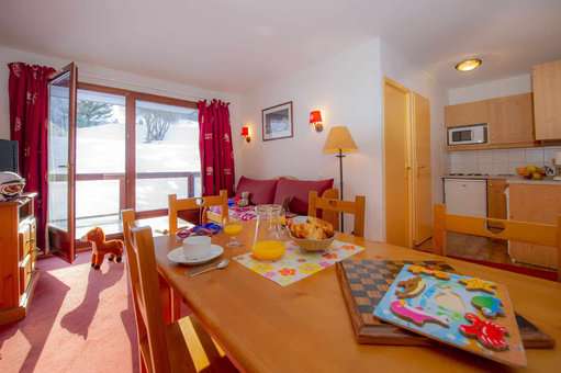 Living room and kitchenette of an apartment of the holiday residence Goélia Les Terrasses du Corbier au Corbier in winter