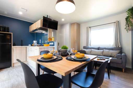 Example of a living room with a kitchen in the Camping Club Les Amiaux in St Jean de Monts Example of a living room with a kitchen in the Camping Club Les Amiaux in St Jean de Monts