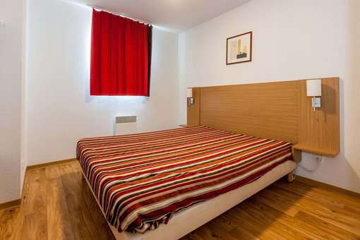 Exemple de chambre avec un lit double dans la résidence de vacances Les Cimes du Val d'Allos dans les Alpes du Sud