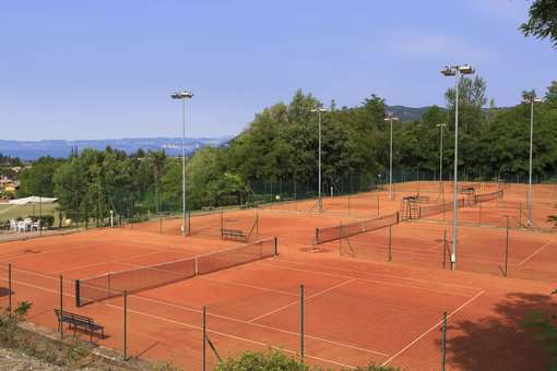 Terrains de tennis de la résidence de vacances Poiano Resort à Garda, proche du Lac de Garde, en Italie