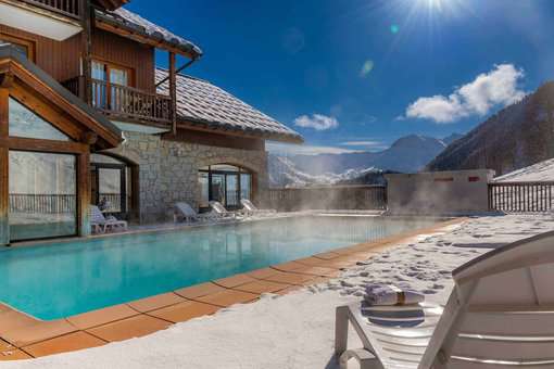Outdoor and heated outdoor swimming pool of the holiday residence Goélia Les Alpages du Corbier in winter