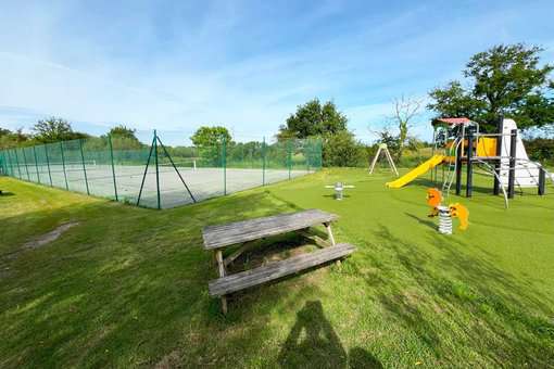 Tennis court and playground for children in the green spaces of the holiday residence Goélia Le Cordouan in Soulac-sur-Mer