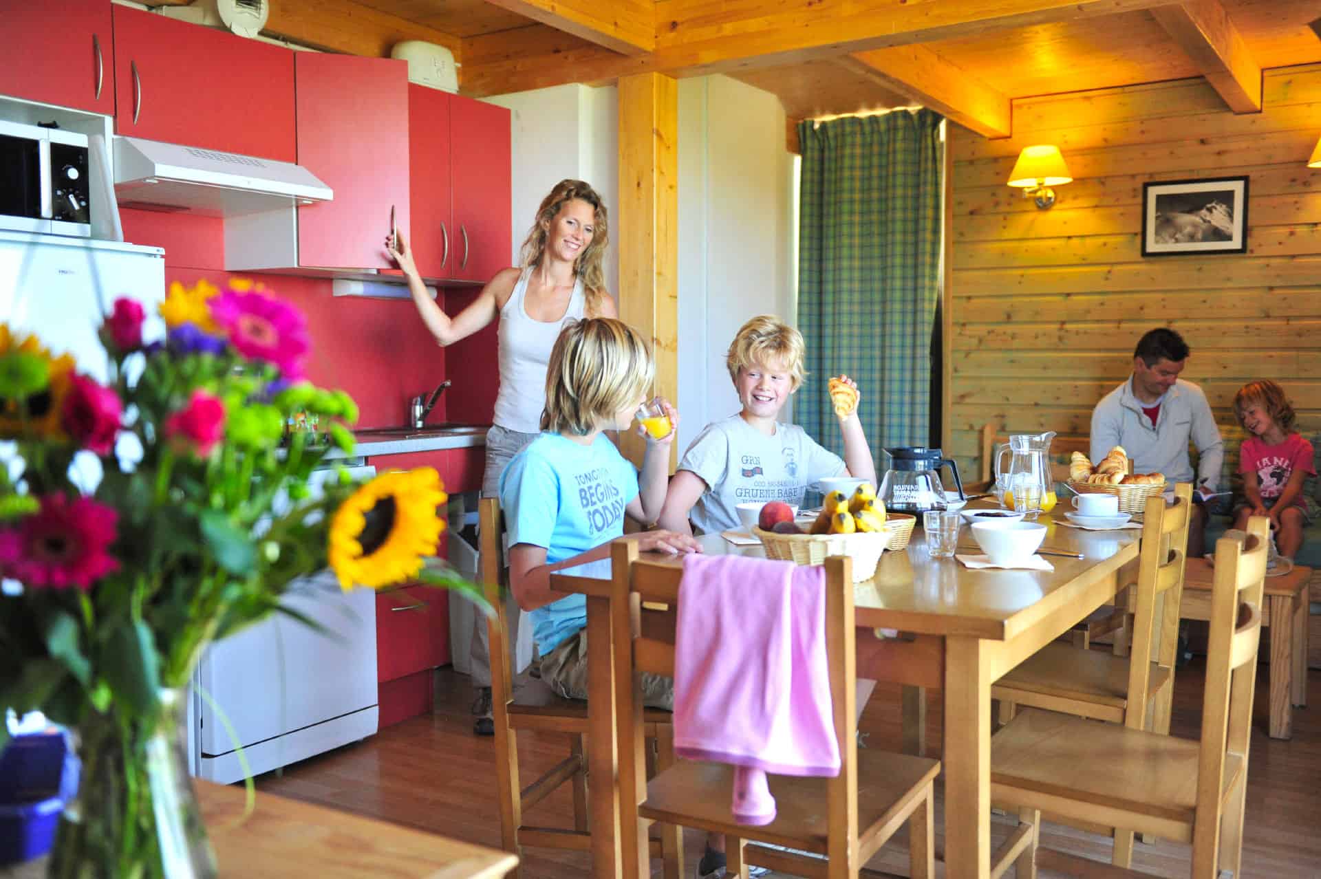 Salon et kitchenette d'un appartement de la résidence de vacances Goélia Le Domaine de Castella à Font-Romeu Salon et kitchenette d'un appartement de la résidence de vacances Goélia Le Domaine de Castella à Font-Romeu
