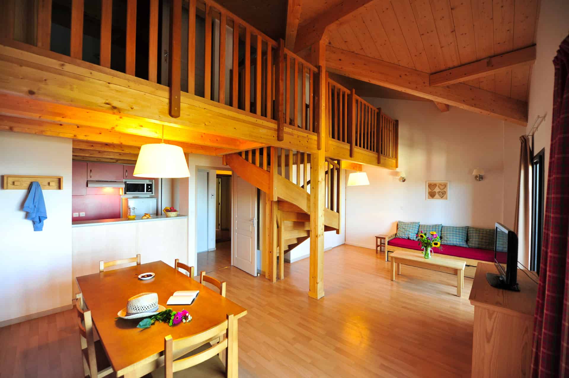 Salon et kitchenette d'un appartement de la résidence de vacances Goélia Le Domaine de Castella à Font-Romeu Salon et kitchenette d'un appartement de la résidence de vacances Goélia Le Domaine de Castella à Font-Romeu