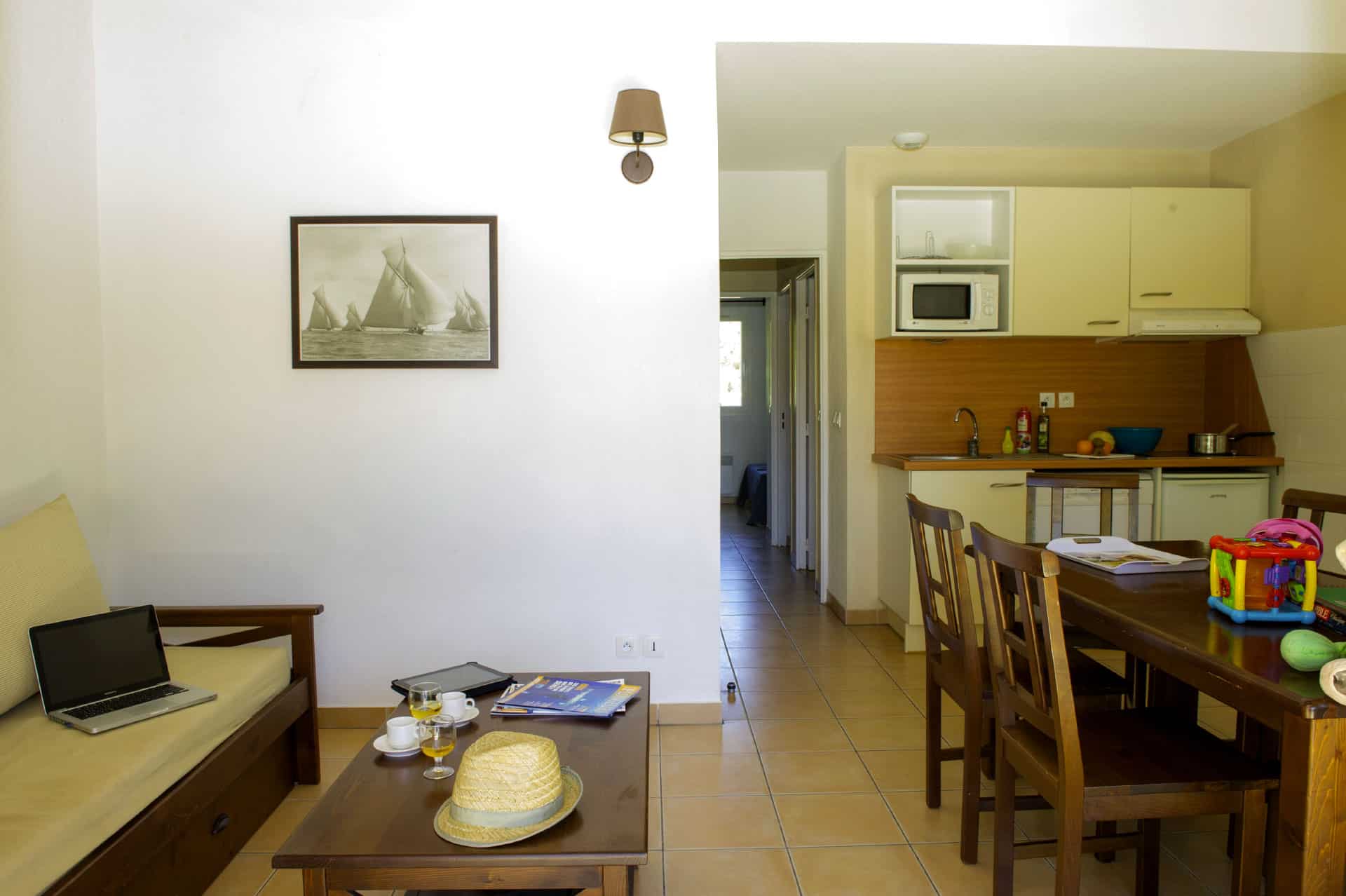 Living room and kitchenette of an apartment of the holiday residence Goélia Cap Bleu in Carro Living room and kitchenette of an apartment of the holiday residence Goélia Cap Bleu in Carro