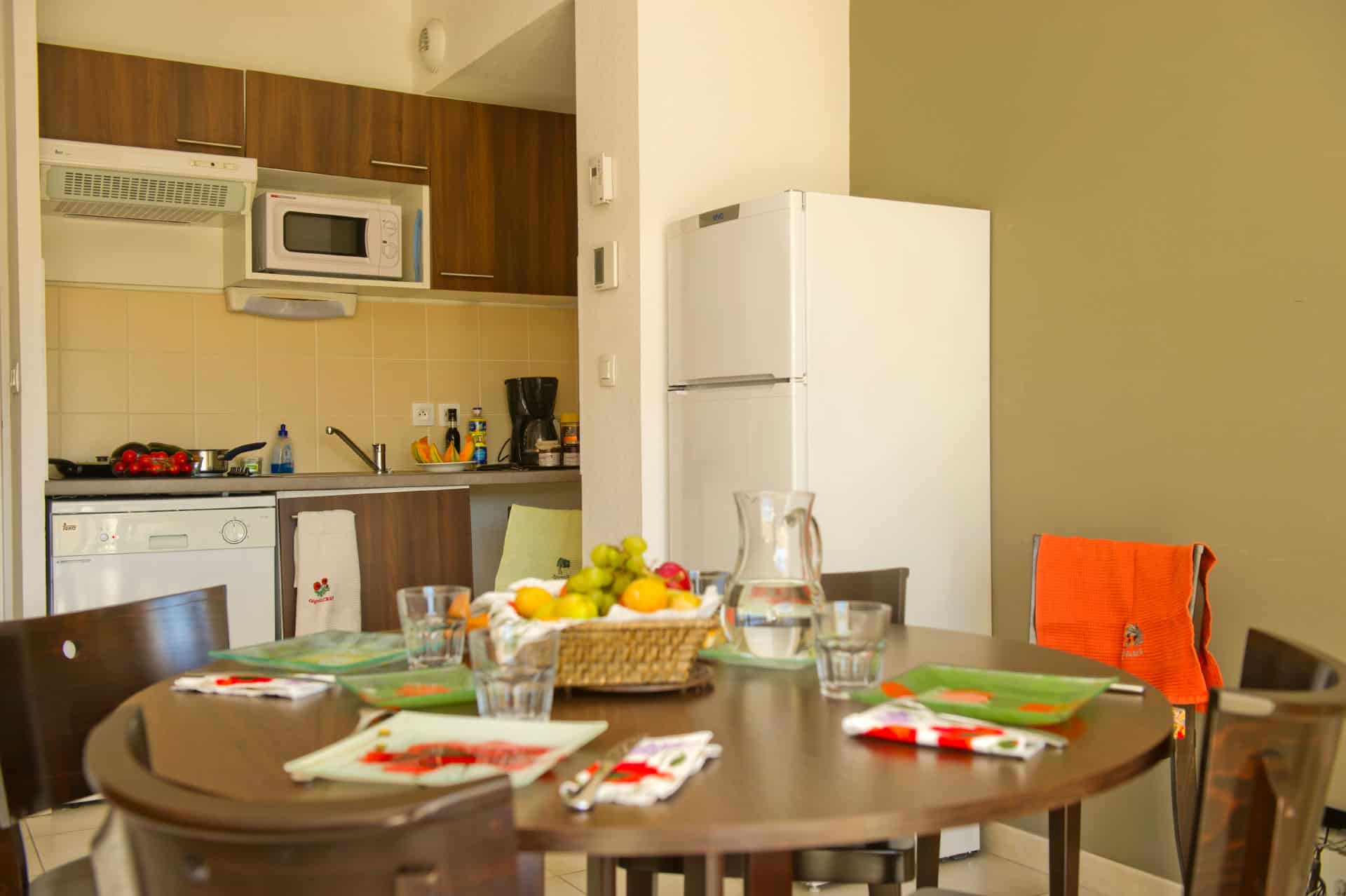 Living room and kitchenette of an apartment of the holiday residence Goélia Le Domaine du Moulin Blanc in Gordes Living room and kitchenette of an apartment of the holiday residence Goélia Le Domaine du Moulin Blanc in Gordes