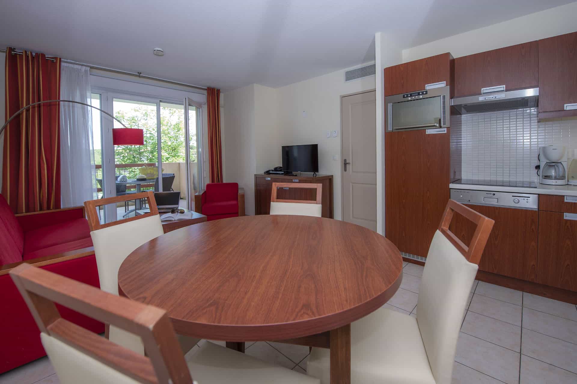 Salon avec kitchenette d'un appartement de la résidence de vacances Goélia Mandelieu Riviera Resort à Mandelieu La Napoule Salon avec kitchenette d'un appartement de la résidence de vacances Goélia Mandelieu Riviera Resort à Mandelieu La Napoule