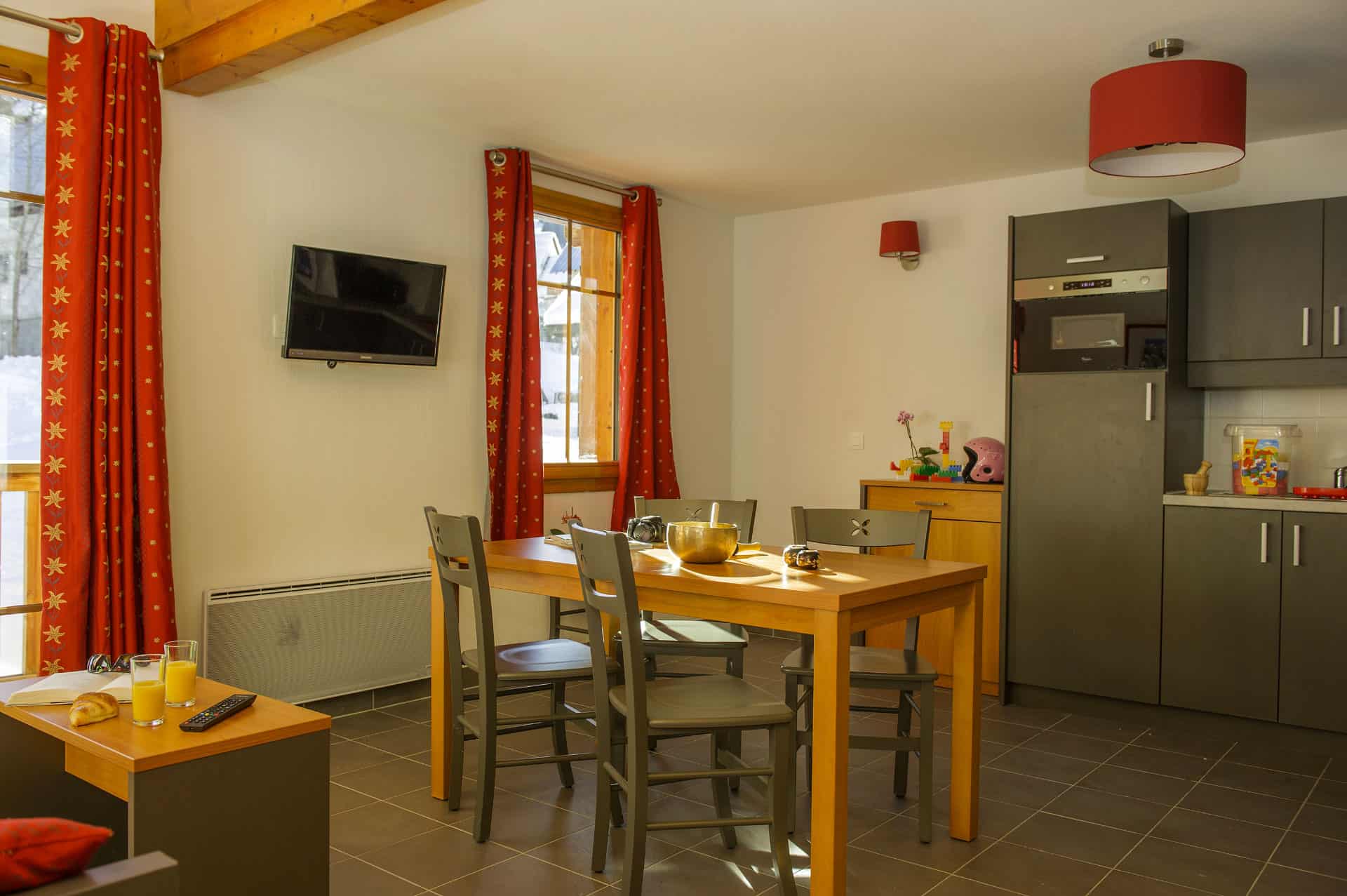 Exemple de salon avec kitchenette dans la résidence de vacances Goélia Les Chalets de Belledonne à St Colomban Les Sybelles Exemple de salon avec kitchenette dans la résidence de vacances Goélia Les Chalets de Belledonne à St Colomban Les Sybelles