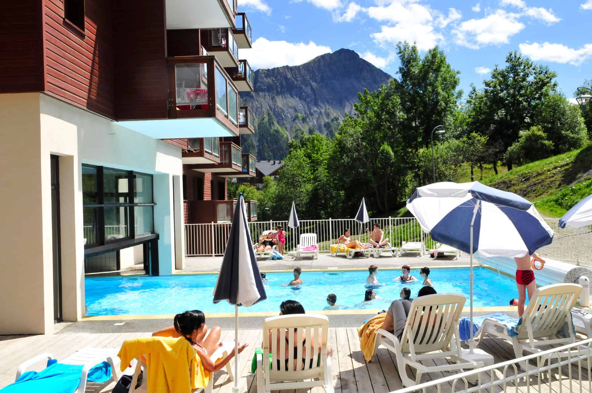 Piscine intérieure et extérieure chauffée de la résidence de vacances Goélia Les Terrasses du Corbier au Corbier en été