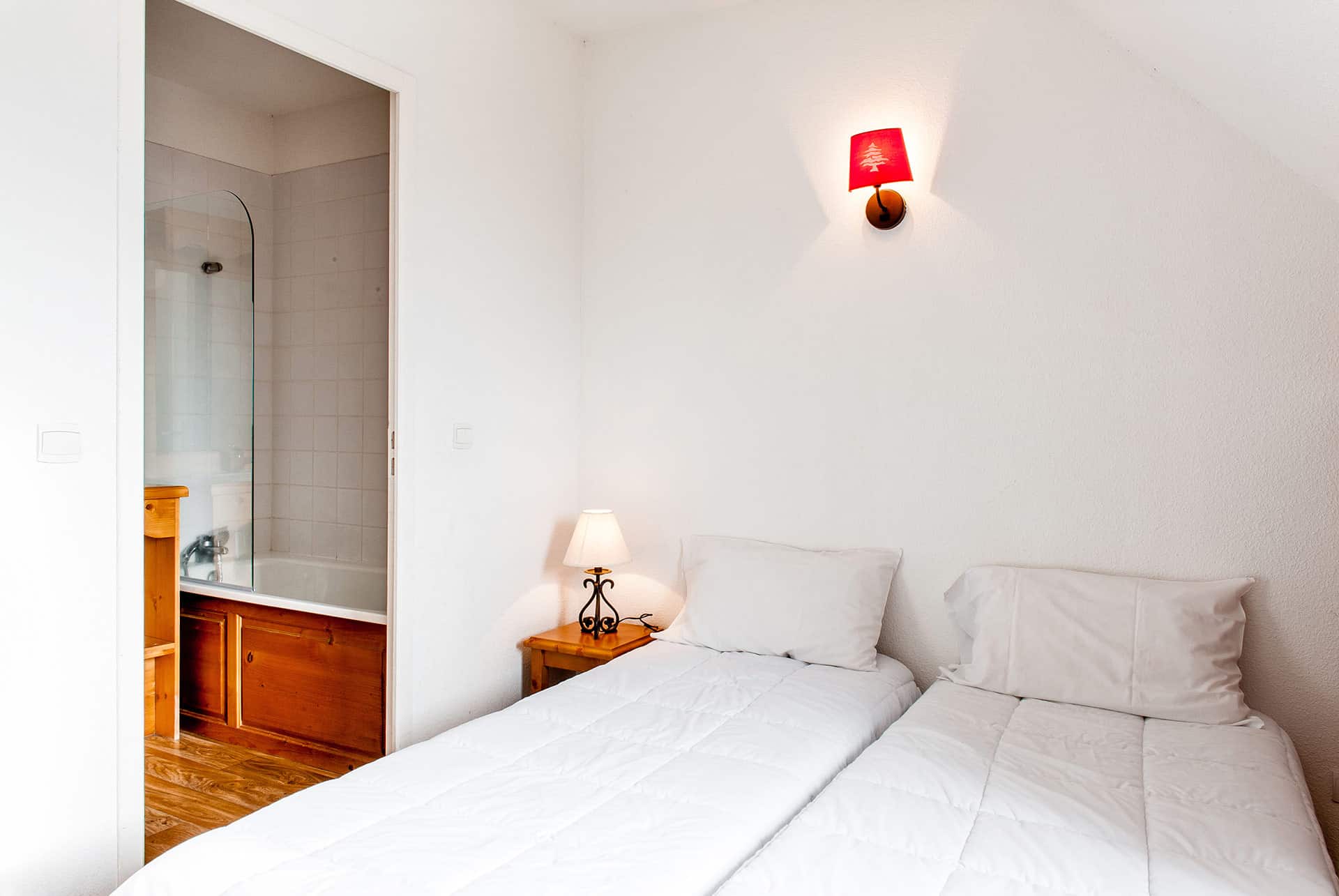 Exemple de chambre avec 2 lits simples d'un appartement de la résidence de vacances Le Bois de la Reine à Super-Besse Exemple de chambre avec 2 lits simples d'un appartement de la résidence de vacances Le Bois de la Reine à Super-Besse