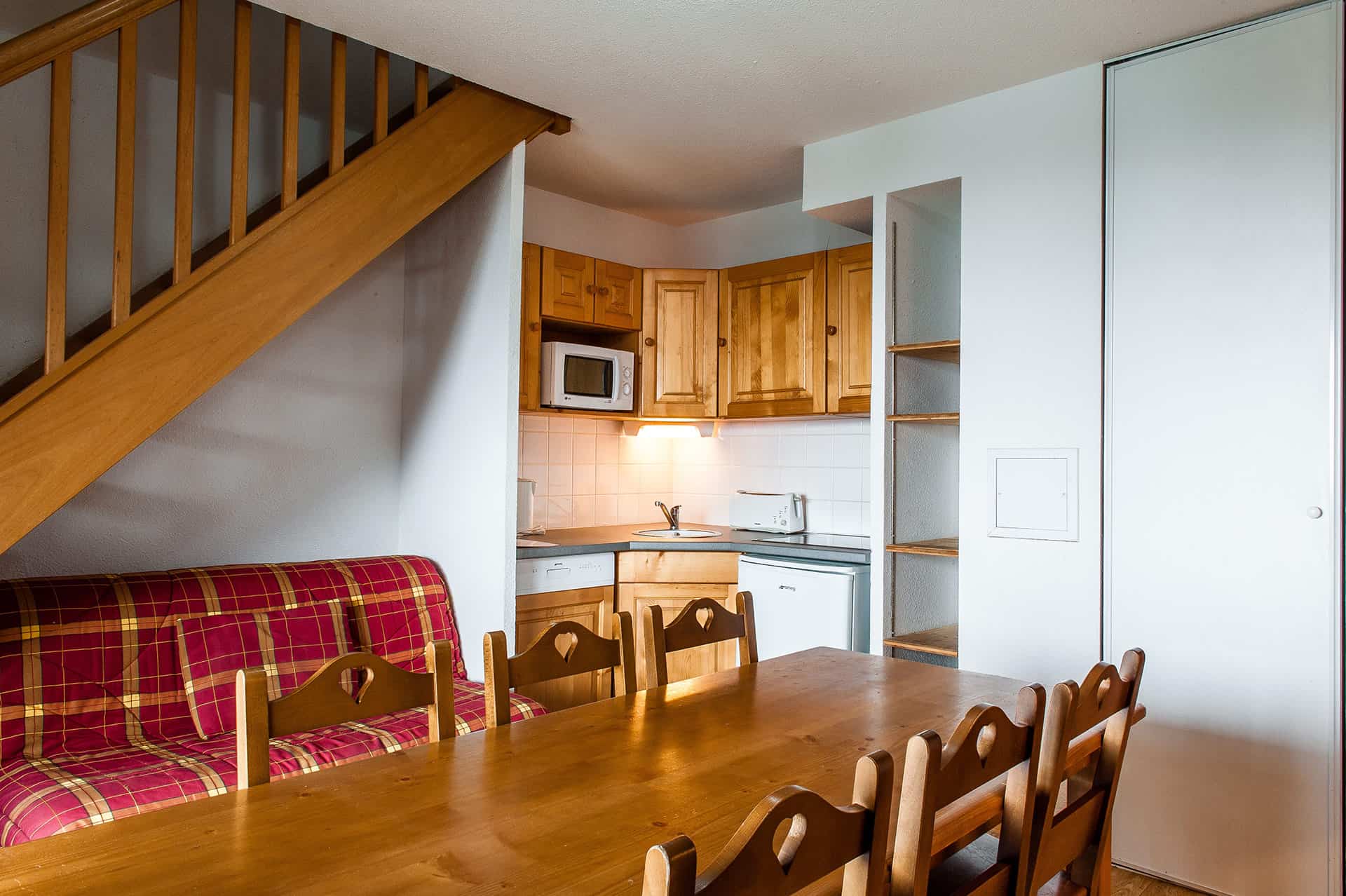 Exemple de salon et kitchenette d'un appartement de la résidence de vacances Le Bois de la Reine à Super-Besse Exemple de salon et kitchenette d'un appartement de la résidence de vacances Le Bois de la Reine à Super-Besse