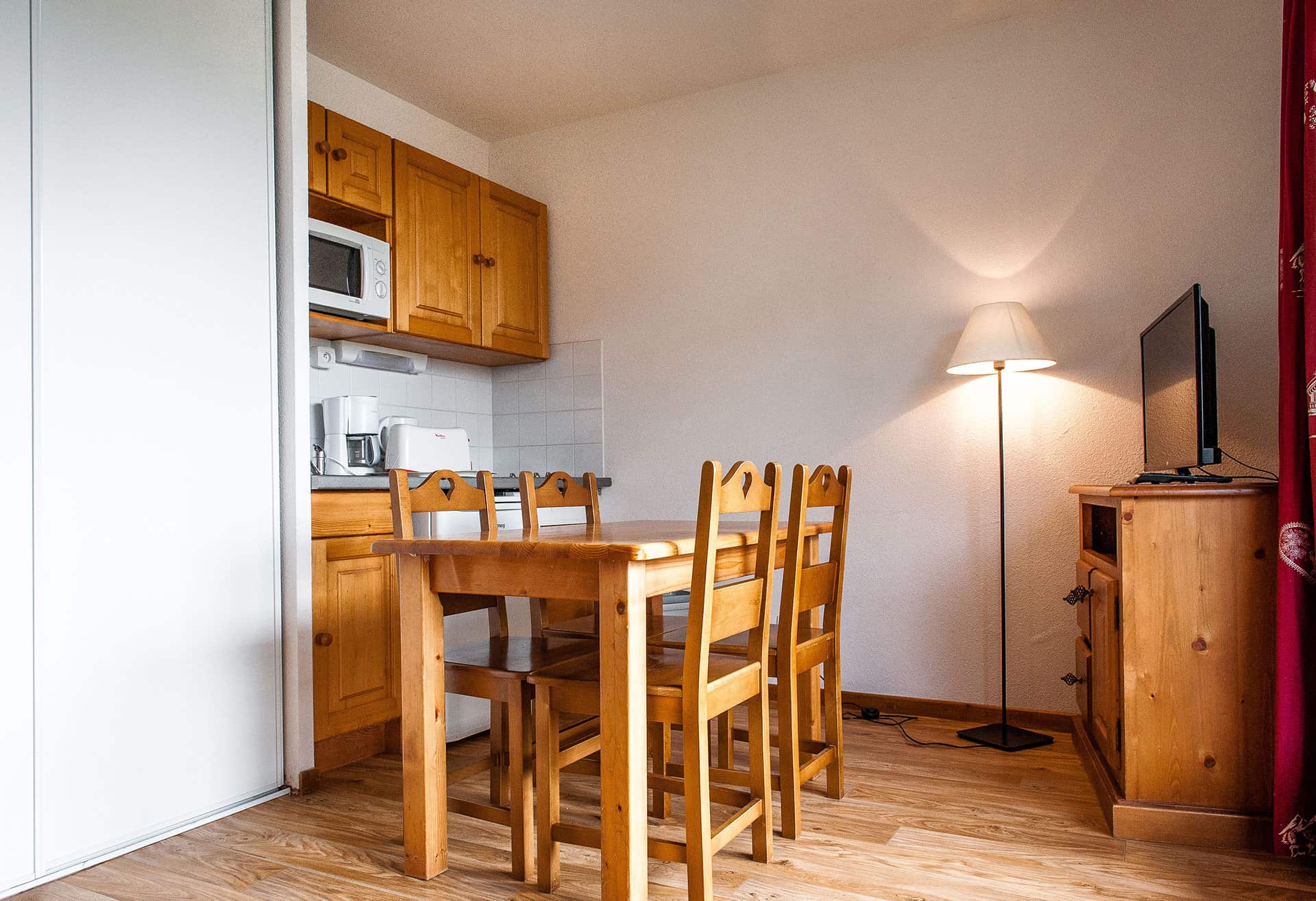 Exemple de salon et kitchenette d'un appartement de la résidence de vacances Le Bois de la Reine à Super-Besse Exemple de salon et kitchenette d'un appartement de la résidence de vacances Le Bois de la Reine à Super-Besse