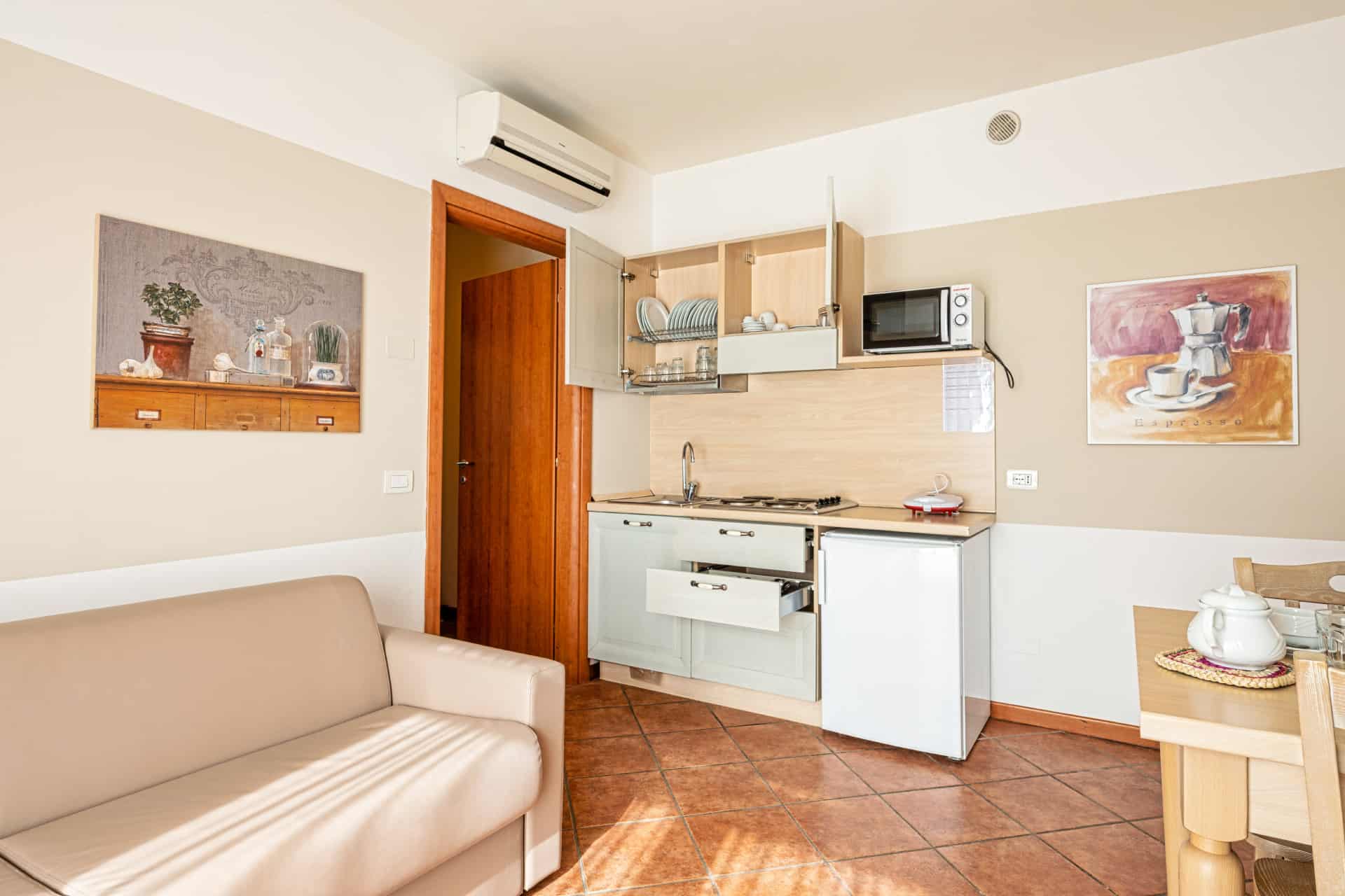 Exemple de séjour avec coin cuisine d'un appartement de la résidence de vacances Eden à Peschiera del Garda, proche du Lac de Garde, en Italie Exemple de séjour avec coin cuisine d'un appartement de la résidence de vacances Eden à Peschiera del Garda, proche du Lac de Garde, en Italie