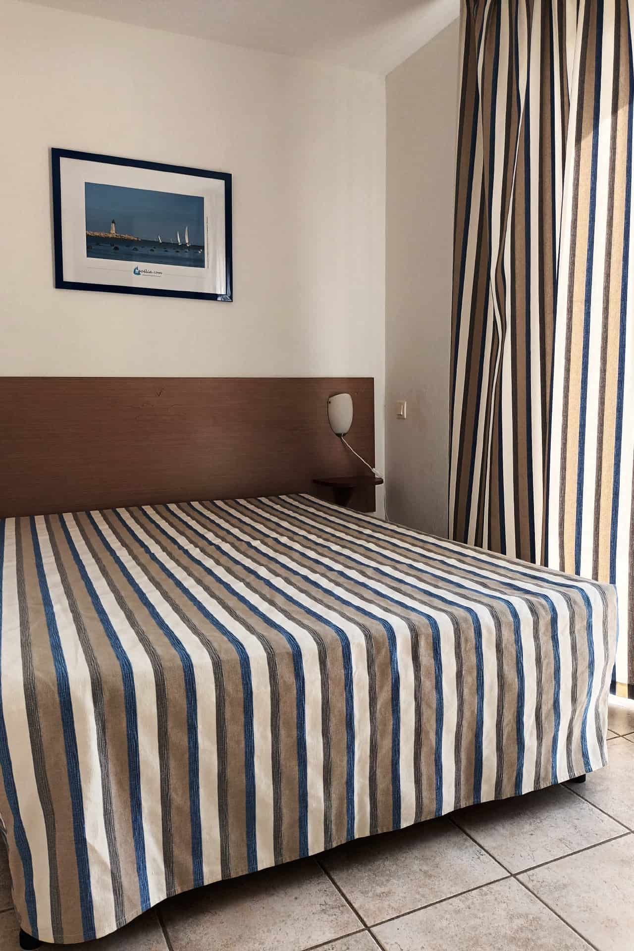 Chambre avec lit double d'un appartement de la résidence de vacances Les Jardins de Phoebus à Gruissan, Occitanie Chambre avec lit double d'un appartement de la résidence de vacances Les Jardins de Phoebus à Gruissan, Occitanie