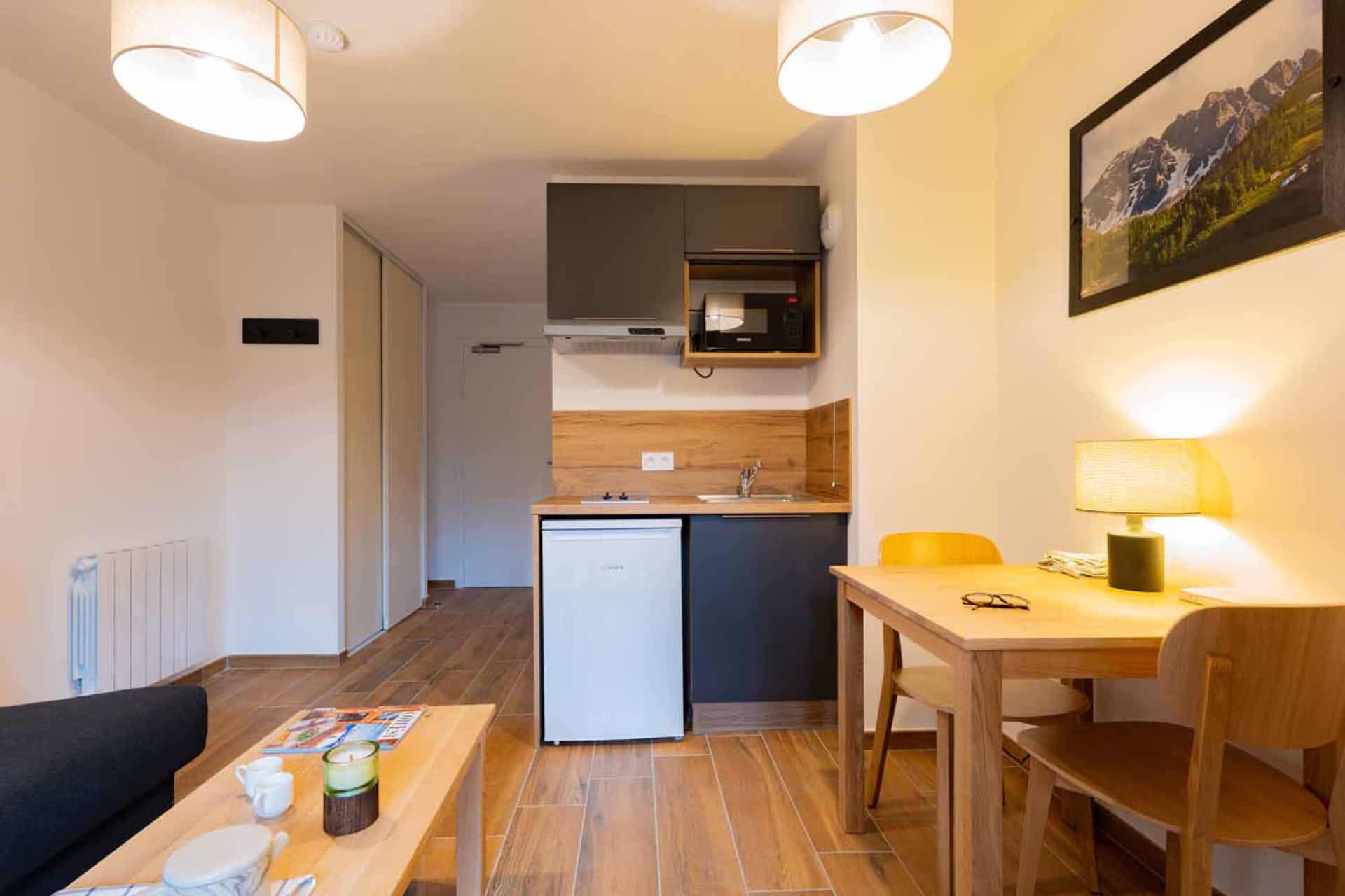 Séjour avec cuisine équipée d'un studio pour 2 personnes de la résidence de vacances Arya Living Stone à Vars dans les Alpes du Sud Séjour avec cuisine équipée d'un studio pour 2 personnes de la résidence de vacances Arya Living Stone à Vars dans les Alpes du Sud