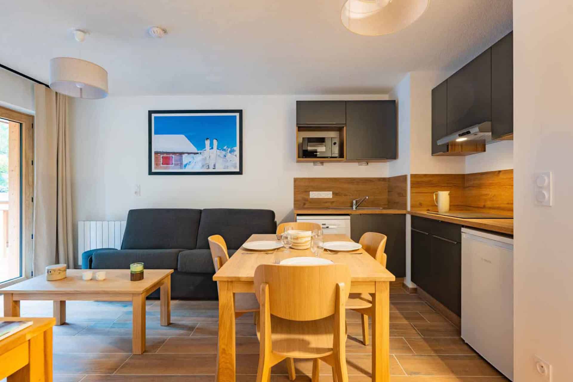 Salon avec cuisine équipée d'un 2 pièces pour 4 personnes de la résidence de vacances Arya Living Stone à Vars dans les Alpes du Sud Salon avec cuisine équipée d'un 2 pièces pour 4 personnes de la résidence de vacances Arya Living Stone à Vars dans les Alpes du Sud