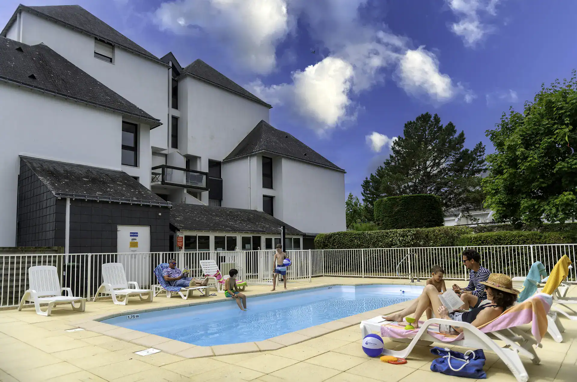 Piscine extérieure chauffée avec chaises longues de la résidence de vacances Goélia Bleue Océane à Carnac