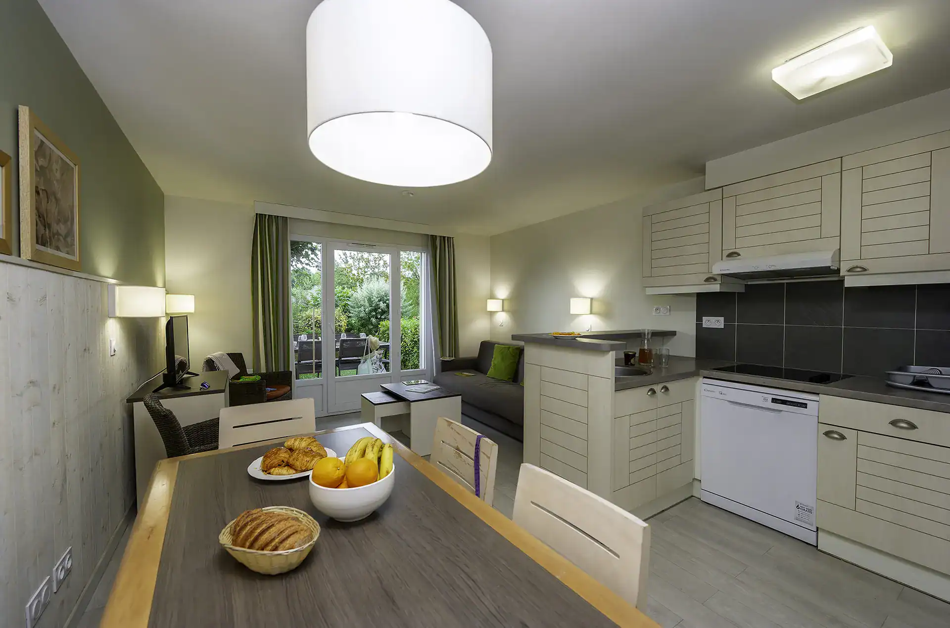 Exemple de coin repas et de kitchenette de la résidence de vacances Goélia  La Pommeraie à Branville 