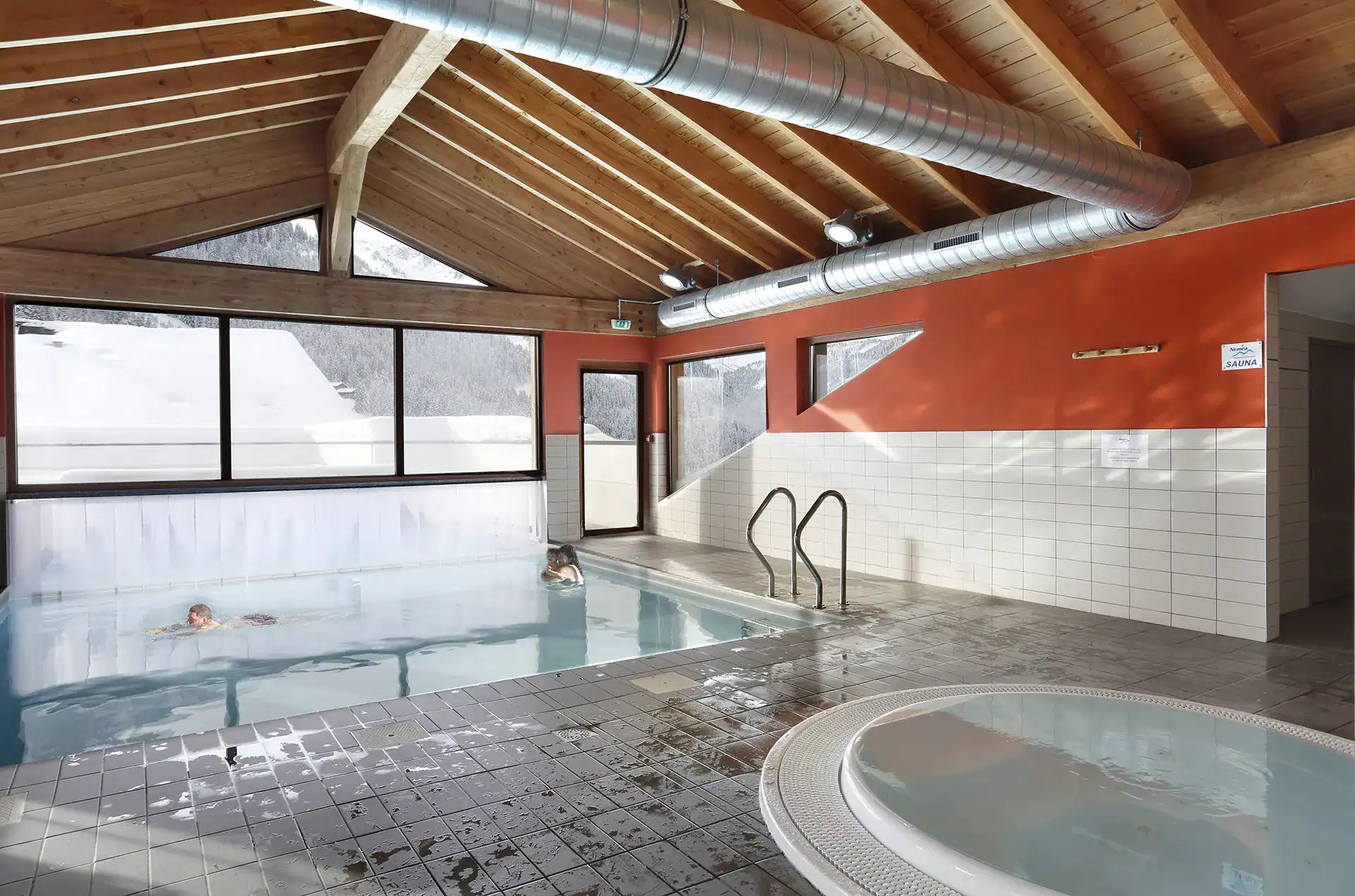 Heated indoor/outdoor swimming pool at the Goélia Le Grand Lodge holiday residence in Châtel with hot tub