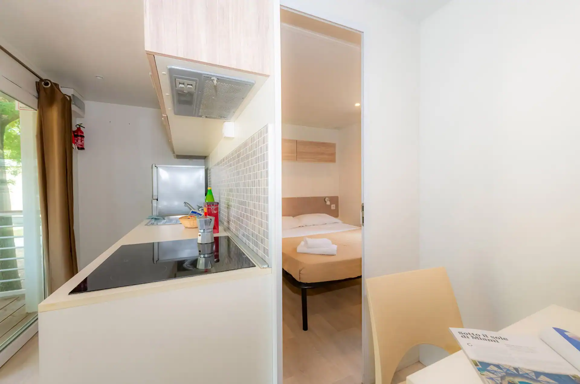 Exemple de chambre et coin kitchenette d'un mobile-home prestige de la résidence de vacances The Garda Village à Comombare di Sirmione en Italie