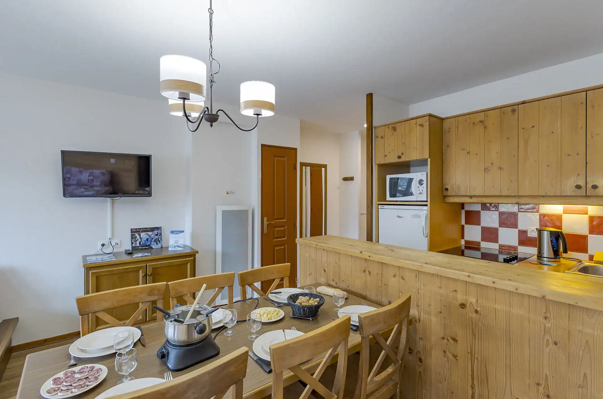Example of a living room and kitchenette at the Goélia Les Chalets de Valoria holiday residence in Valloire